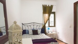 Ein Schlafzimmer mit einem Bett, einem Nachttisch, einer Lampe und einer dekorativen Laterne.