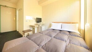 A hotel room with a bed, a desk with a computer, a chair, and a door. - R&B Morioka-ekimae (Morioka)