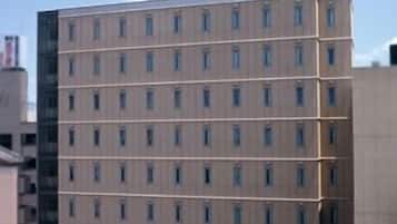 Un hotel de varios pisos con un llamativo letrero de R&B en la parte superior, que presenta una fachada uniforme con ventanas distribuidas regularmente.