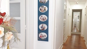 A hallway with a wooden floor, a welcome sign, and a photo collage on the wall. - Ameli Rooms (Lisbon)