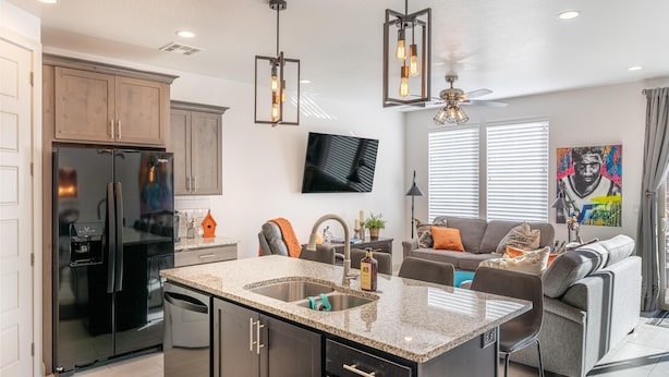 A modern kitchen with a built-in refrigerator, granite countertops, and a central island with a sink.