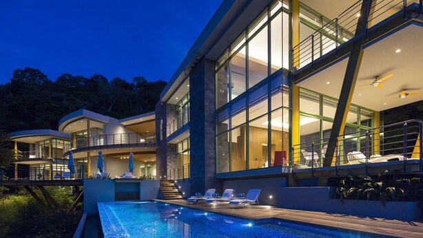 A modern house with a large glass facade, a swimming pool, and outdoor seating areas. - Oceanview Escape in Peninsula Papagayo – Pool, Concierge & Resort Access (Peninsula Papagayo)