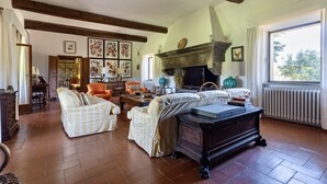 A spacious living room with a fireplace, comfortable seating, and a large window providing natural light.