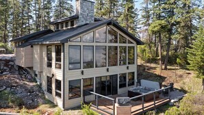 A modern cabin with a large deck, surrounded by forest. - Modern Mountain Lake House - 3 bedrooms + Master Loft (Polson)