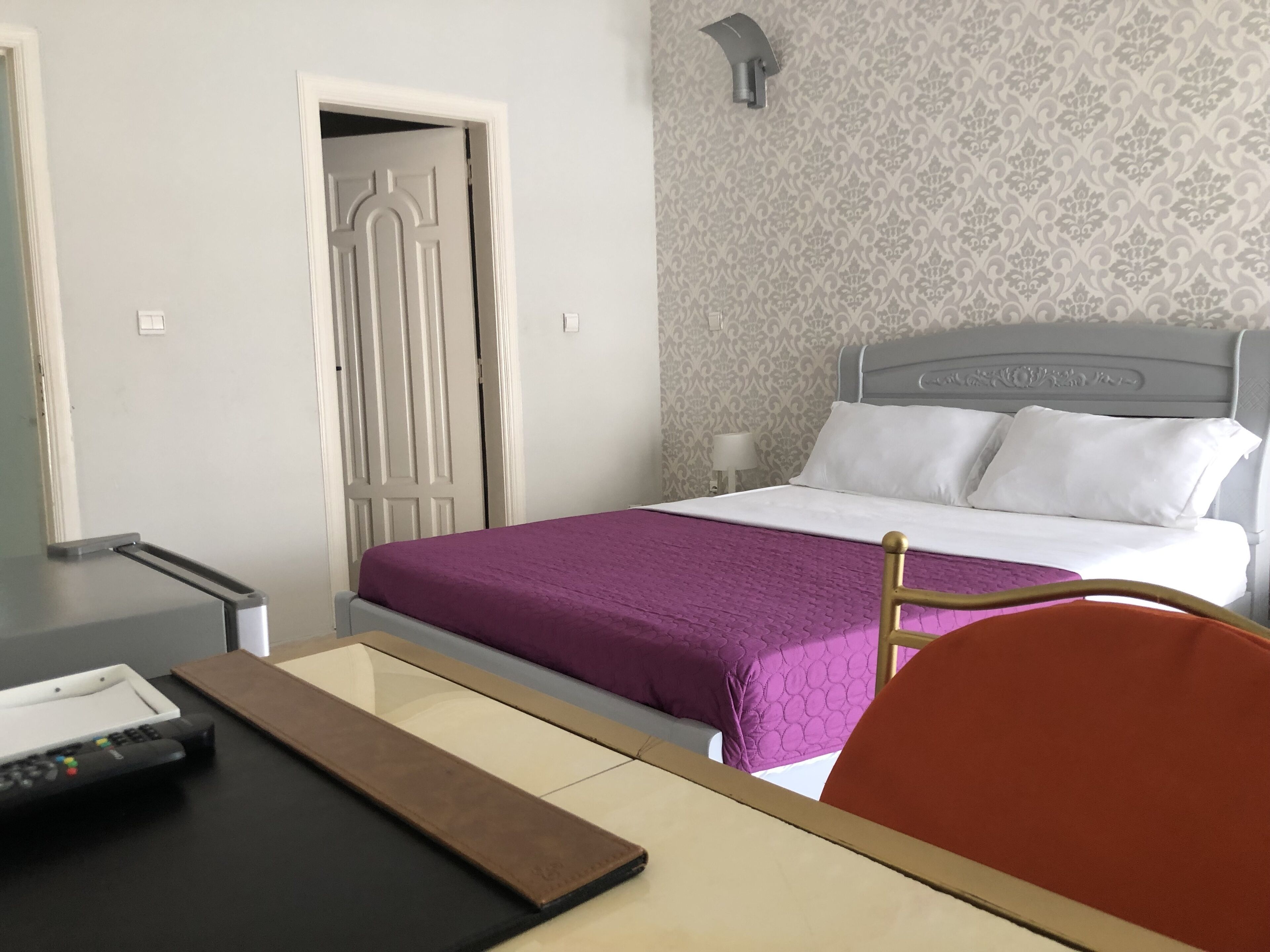 Una habitación de hotel con una cama, un escritorio y una silla.