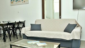 Una sala de estar con sofá, mesa de centro y comedor.