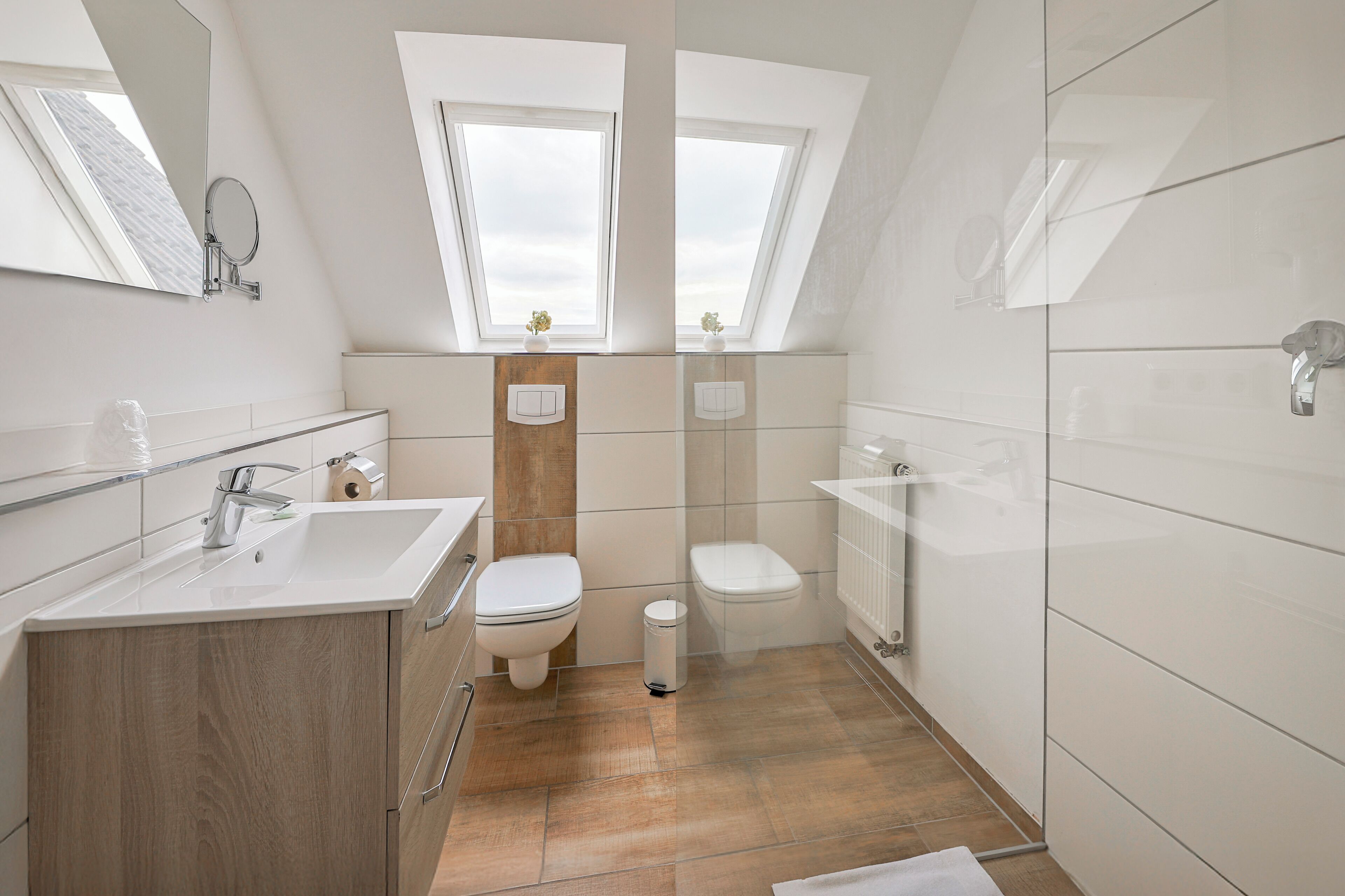 Un baño moderno con tragaluz, un lavabo, un inodoro y una zona de ducha.