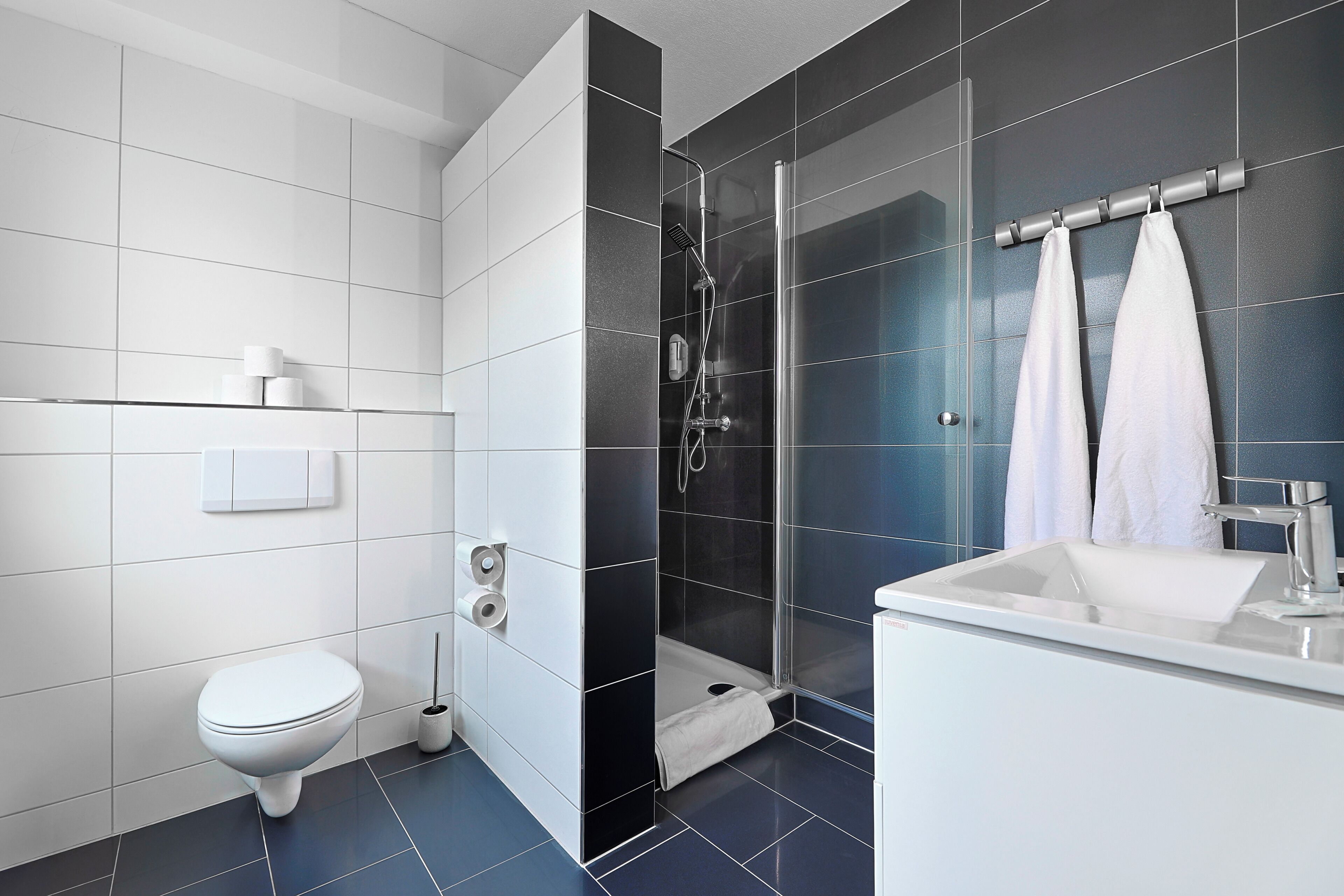 Un baño moderno con inodoro, ducha y lavamanos.
