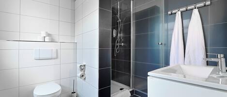 Un baño moderno con inodoro, ducha y lavamanos.