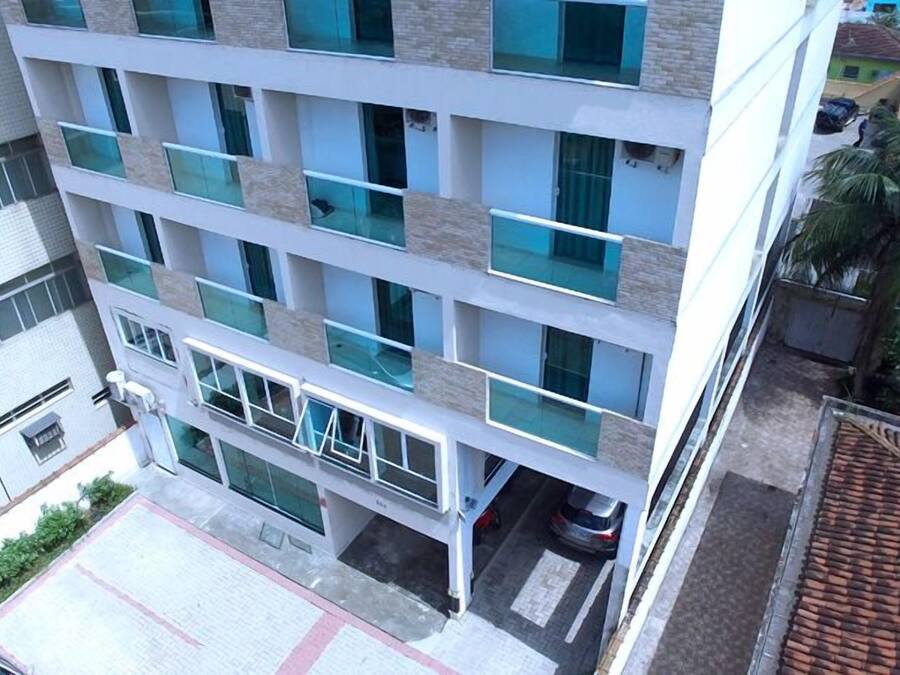 Un edificio de varios pisos con un diseño arquitectónico moderno, que presenta una serie de balcones y grandes ventanales.