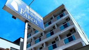 A multi-story hotel building with a sign that reads "Hotel do Faro." - Hotel do Farol (Cubatao)