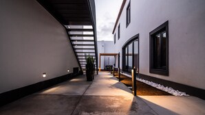 A modern building with a concrete pathway, a potted plant, and a staircase leading to an upper level. - Villa Esmeralda (Ponta Delgada)