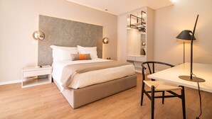 A modern bedroom with a large bed, bedside tables, a desk, and a chair. - Villa Esmeralda (Ponta Delgada)