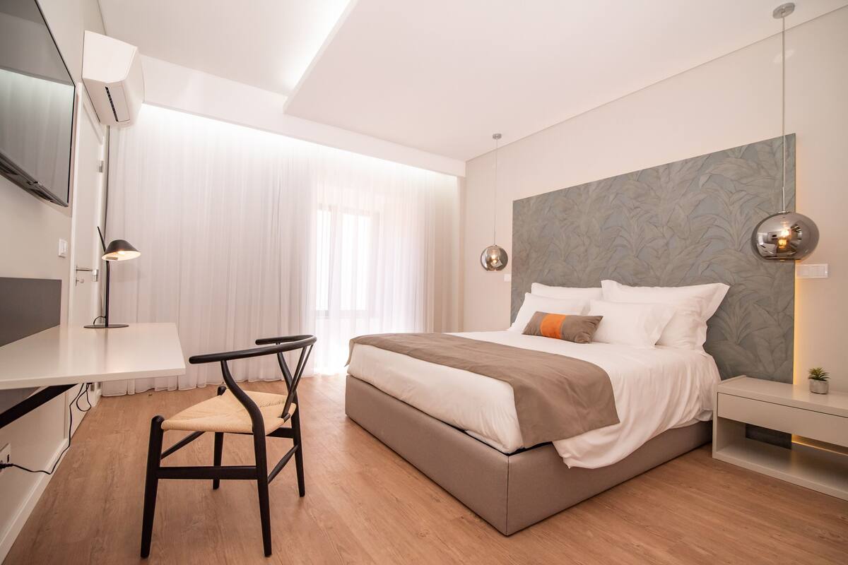 Un dormitorio moderno con cama, escritorio y silla.