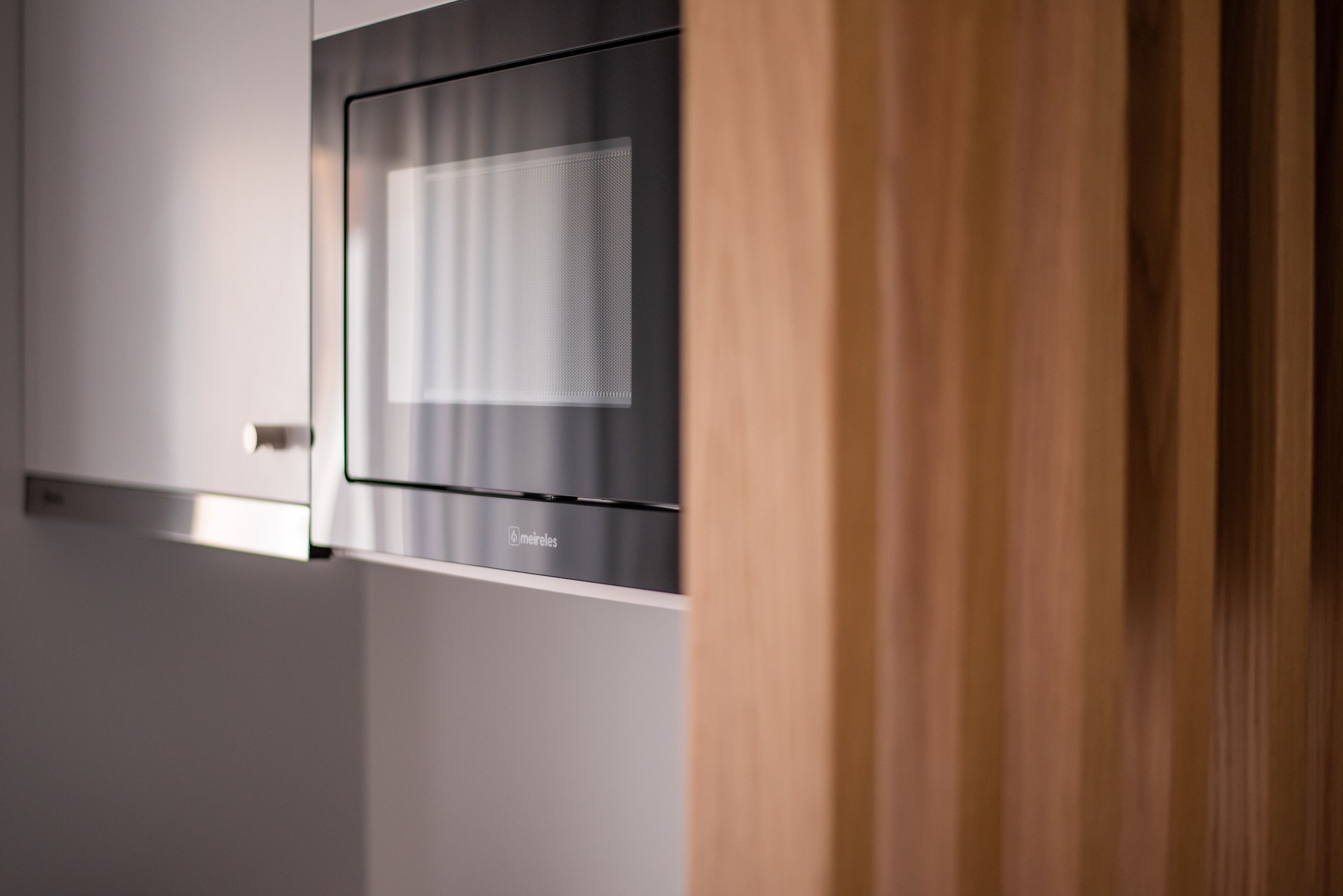 A modern interior with a glass partition and a wooden door.