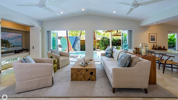 A spacious living room with a large TV, comfortable seating, and a view of a pool and outdoor area. - **MIDTOWN MOSAIC @ MIDTOWN** Home & Pool + Last Key White Glove Service... (Key West)