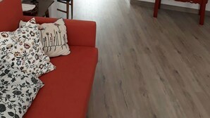 A living room with a red sofa, a wooden cabinet, and a chandelier. - Apartment, center of Madrid, Embajadores area (Madrid)