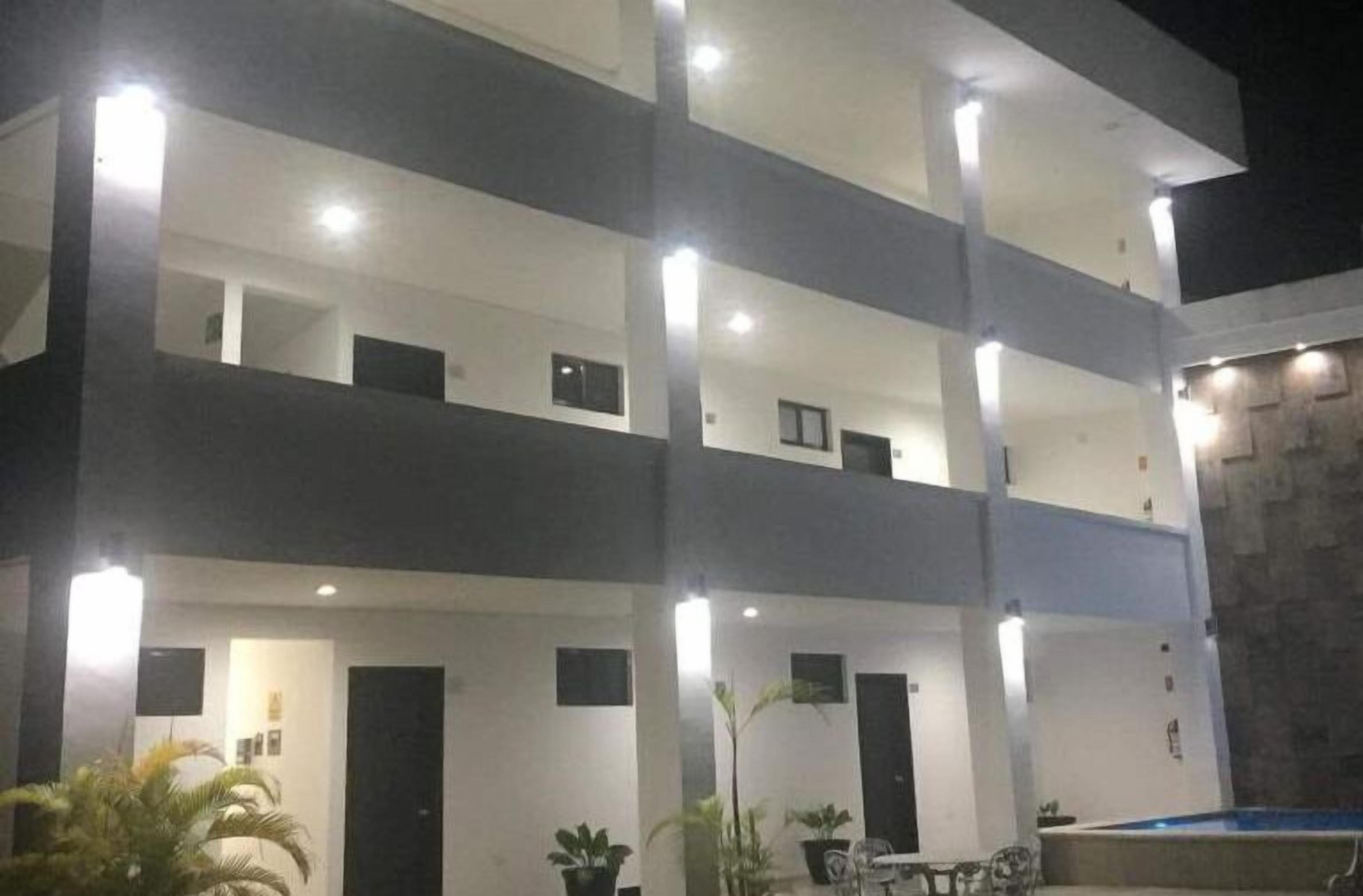 Un edificio de varios pisos con balcones y una zona de piscina.