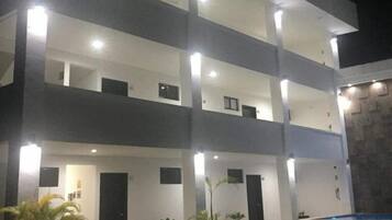 Un edificio de varios pisos con balcones y una zona de piscina.