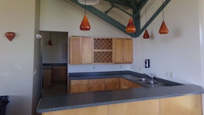 A kitchen with wooden cabinets, a granite countertop, and pendant lighting. - Three House 2 Bed 2 Bath THWC (Silverthorne)