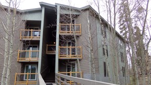 A multi-story building with a central staircase leading to an upper floor. - Three House 2 Bed 2 Bath THWC (Silverthorne)