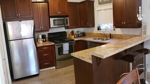 A modern kitchen with wooden cabinets, stainless steel appliances, and a large island.