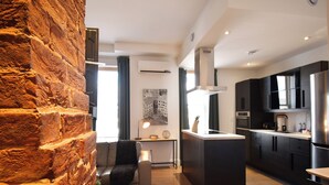 Una cocina moderna con armarios oscuros, una isla central y un horno empotrado.