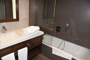 Superior appartement | Badkamer | Een bad/douchecombinatie, een haardroger, handdoeken, zeep