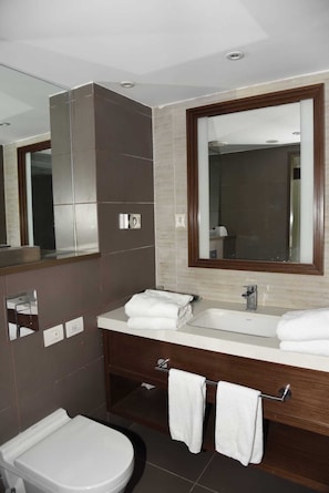 Superior appartement | Badkamer | Een bad/douchecombinatie, een haardroger, handdoeken, zeep