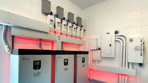 Une pièce propre et moderne, dotée d’un grand radiateur de style industriel et de panneaux de commande fixés au mur.