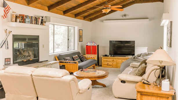 Una sala de estar acogedora con chimenea, televisor y asientos cómodos.