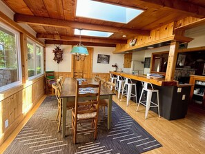 A wooden interior with a dining area, bar, and kitchen. - O'Connell Lake Area retreat nestled amongst towering pines (Bass Lake)