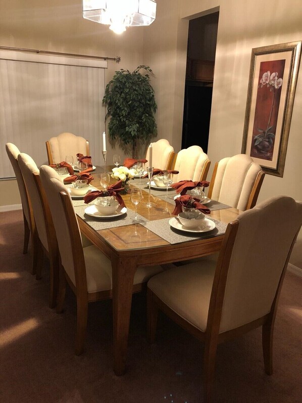 Comedor con una mesa rectangular dispuesta para seis personas, rodeada de sillas tapizadas.
