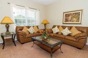 Relax in this inviting living room with a leather sofa, coffee table, and artwork.