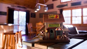 Ein Holzmodell eines Angelgeschäfts mit einem Schild, auf dem 'BAIT SHOP' und 'ERÖFFNET 4:00 UHR' steht.