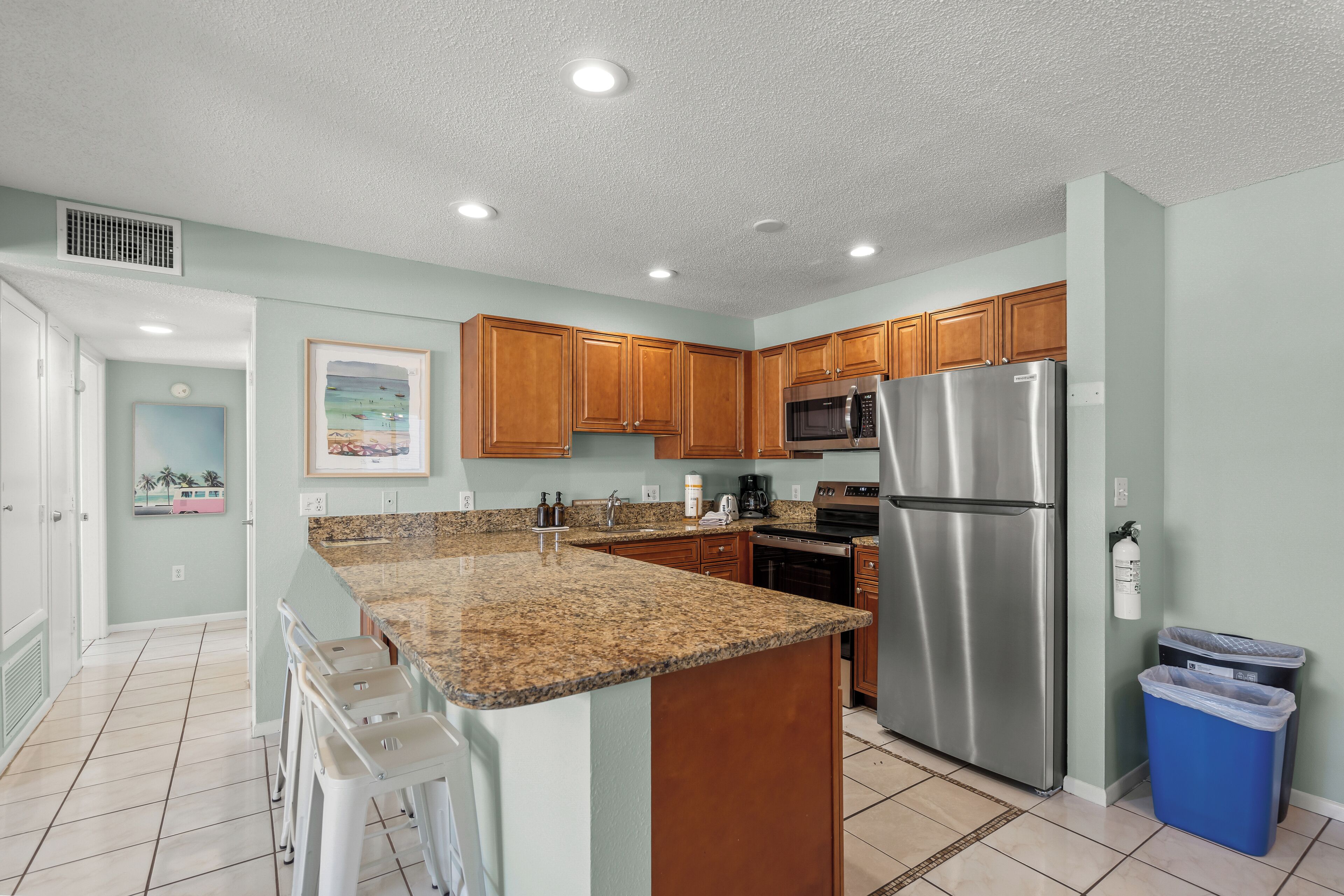 A modern kitchen with granite countertops, stainless steel appliances, and wooden cabinets.