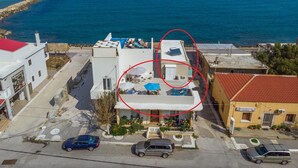 Un immeuble situé sur la côte, doté d’une piscine sur le toit, d’un petit jardin et offrant une vue sur la mer.