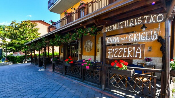 Un restaurante llamado "Carmila Griglia" con terraza y decoración floral.