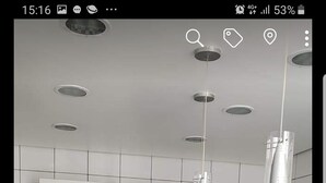 Una cocina moderna con armarios blancos, encimeras negras y electrodomésticos de acero inoxidable.