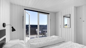 A bedroom with a bed, a desk, a chair, and a window with a view of the outside. - Stunning home in Hvide Sande with sauna (Hvide Sande)