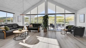 A spacious living area with a high ceiling, large windows, and a view of the outdoors. - Stunning home in Hvide Sande with sauna (Hvide Sande)