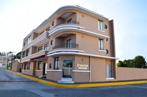 Un hotel de varios pisos con fachada curva, balcones y una entrada despejada.