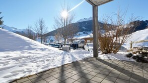 A covered parking area with snow-covered ground and mountains in the background. - Surses Alpin by Interhome (Savognin)