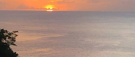 A sunset over a calm sea with a clear horizon.