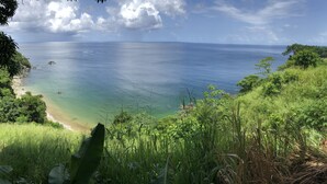 A coastal view with a beach, lush greenery, and a clear sky. - Castara Inn (Castara)
