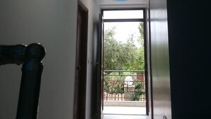 Ein Flur mit eingelassenen Deckenleuchten und Blick auf einen Balkon.
