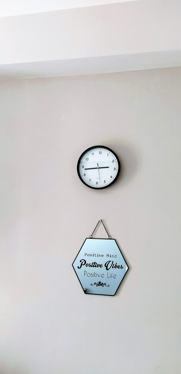 A wall clock and a hexagonal sign with motivational phrases.