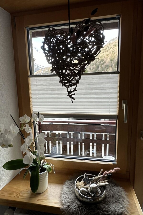 A room with a window, a potted orchid, a decorative bowl, and a wooden bench. - Bergfreude by Interhome (Saas-Grund)