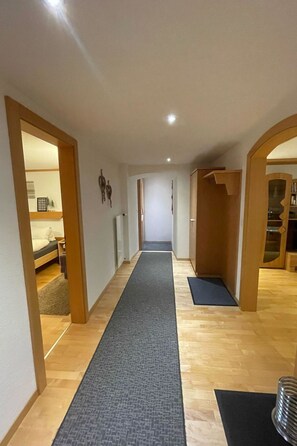 Stylish hallway with a central carpeted area, flanked by rooms with a bed and a dressing area.