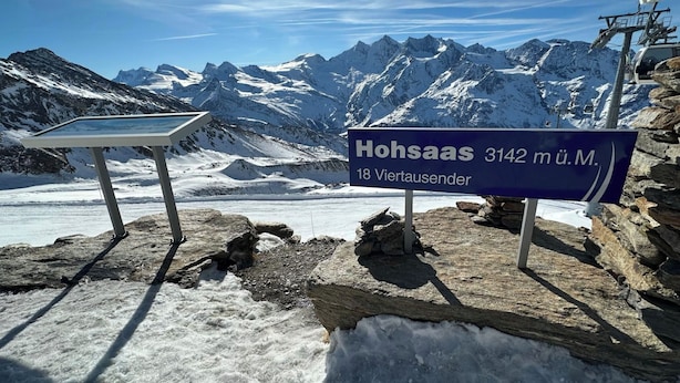 Bord dat de locatie 'Hohsaas 3142 m ü.M.' aangeeft, met uitzicht op besneeuwde bergen en een gletsjer.
